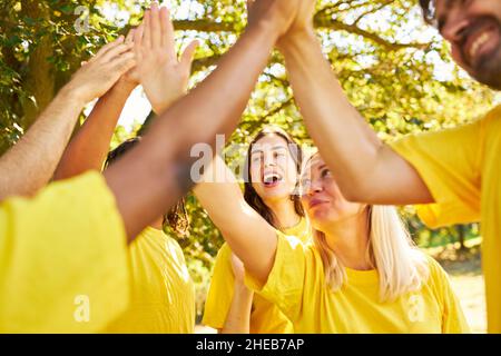 Das Team als Gruppe macht im Sommer hohe fünf für die Motivation beim Teambuilding-Training Stockfoto