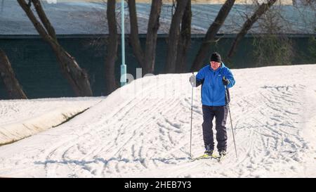 Älterer Mann fährt im Winter draußen auf einer Skipiste. Skilanglauf Stockfoto