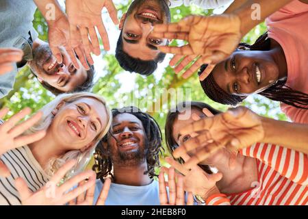 Gruppe junger Menschen im Kreis winkt in einer Teambuilding-Werkstatt in der Natur Stockfoto