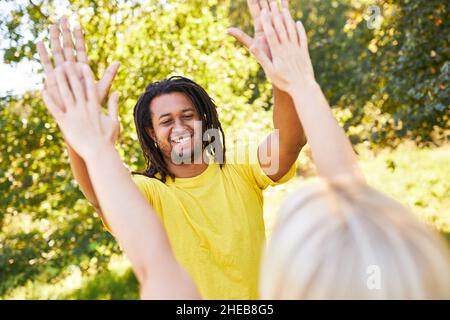 Junge Menschen geben die hohen fünf als Symbol für Zusammenarbeit und Motivation Stockfoto