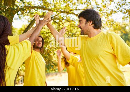Das junge Startup-Team macht im Sommer-Workshop hohe fünf für Motivation und Teambildung Stockfoto