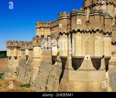 Spanien, Kastilien und Leon, Provinz Segovia. Coca Castle. Es wurde Ende des 15th. Jahrhunderts vom kastilischen Magnaten Don Alonso de Fonseca erbaut. Mudejar-Stil. Zinnen eines Turms. Architektonisches Detail von außen. Stockfoto