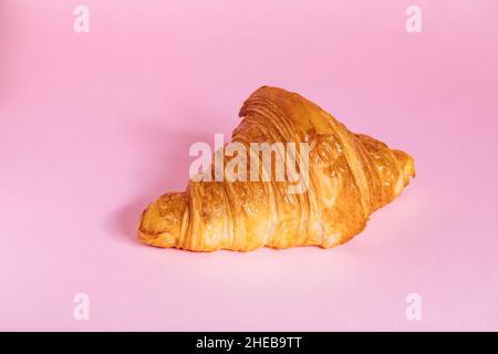 Croissant isoliert auf einem violetten Hintergrund. Einfaches und schönes Konzept. Stockfoto
