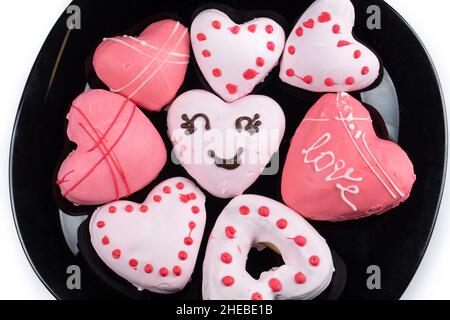 Schöne rosa Lebkuchen oder herzförmige Kekse. Süßes, essbares valentinstagsgeschenk. Stockfoto
