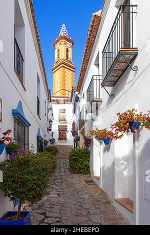 ESTEPONA COSTA DEL SOL ANDALUSIEN SPANIEN WEISSE HÄUSER BUNTE BLUMEN IN TÖPFEN UND TURM DER KIRCHE MARIA DE LOS REMEDIOS Stockfoto