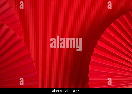 Chinesisches Neujahr. Roter abstrakter Hintergrund mit Handpapierfächer zur Produktpräsentation. Stockfoto