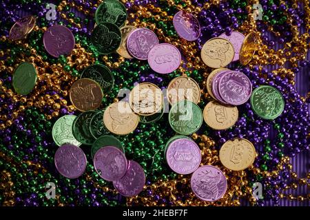 Grün, Gold und lila Mardi Gras Perlen und Münzen Hintergrund Stockfoto