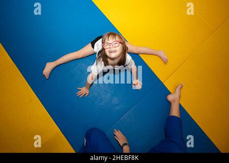 Weißrussland, die Stadt Gomil, 23. Juni 2021. Judo Club. Ein kleines Mädchen mit Down-Syndrom ist in der Turnhalle beschäftigt. Stockfoto