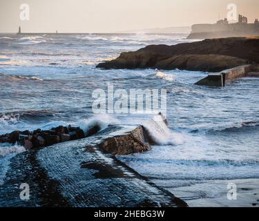 Raue Wellen im Cullercoats Harbour Stockfoto