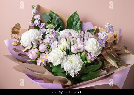 Schönes Bouquet mit Chrysanthemen, Rosen, Nelken auf farbigem Hintergrund Stockfoto