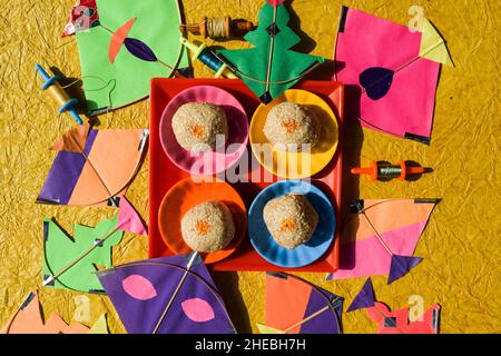 Til laddu oder Sesam ladoo makarsankranti Thema spezielle sankranti traditionelle Süßigkeiten mit bunten Drachen Hintergrund Grußwünsche. sankranti Plakate, Stockfoto