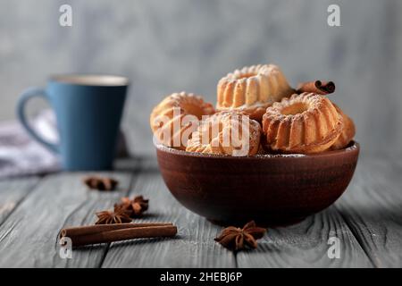 Frisch gebackene hausgemachte Muffins in einer Keramikschale auf Holzboden Stockfoto