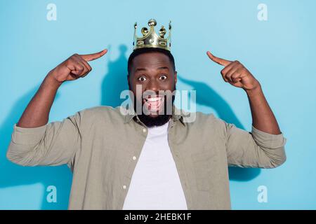 Foto von jungen aufgeregt afrikanischen Mann zeigen Finger Krone select isoliert über blauen Hintergrund Stockfoto