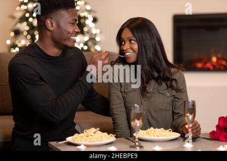 Afroamerikanischer Ehemann Füttert Frau Flirten Während Romantische Datum Indoor Stockfoto