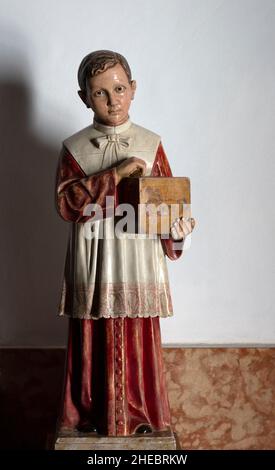 Modell eines Jungen, der am Ausgang der Kirche, Frigiliana, Provinz Malaga, Spanien, eine Opfersammlung hält Stockfoto