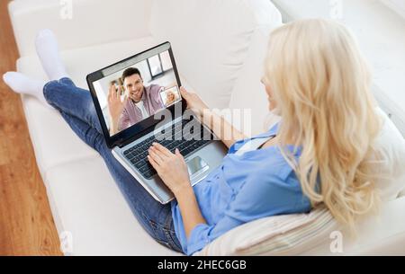 Frau mit Laptop, Videoanruf mit Mann Stockfoto