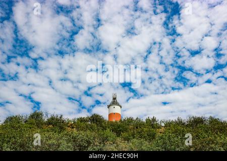 Leuchtturm auf dem Berg vor einem Hintergrund von blauem Himmel und Zirruswolken. Stockfoto