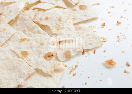 Trockenes, flaches Brot in Stücke gebrochen und geteilt, mit Krümel, auf weißem Hintergrund, kroatische traditionelle Küche mlinci Stockfoto