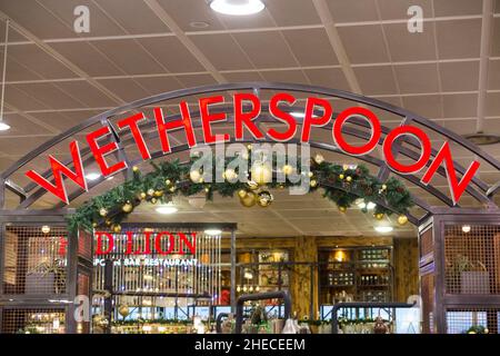 Schild / Beschilderung am Red Lion Wetherspoon / Wetherspoons Pub / Restaurant / Public House, am London Gatwick Airport North Terminal, Crawley. VEREINIGTES KÖNIGREICH. Weihnachten Weihnachtsdekorationen sind sichtbar. (128) Stockfoto
