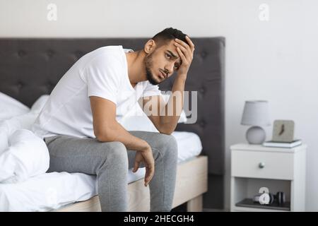 Apathy-Konzept. Porträt Eines Deprimierten Jungen Mannes Aus Dem Nahen Osten, Der Auf Dem Bett Sitzt Stockfoto