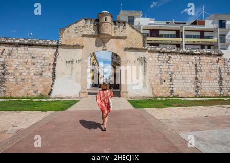 Mexiko, Campeche, ummauerte Stadt, die von der UNESCO zum Weltkulturerbe erklärt wurde, Frau, die zum Eingangstor der ummauerten Stadt Puerta De Mar geht Stockfoto