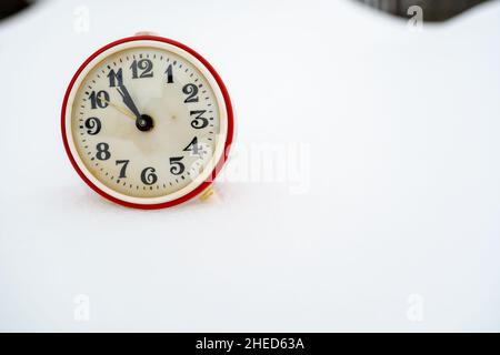 Alte mechanische Wecker im Schnee, an einem Wintertag. Speicherplatz kopieren. Stockfoto