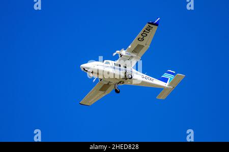 Das italienische zweimotorige Hochflügelflugzeug G-OTAY Tecnam P-2006T von Tayside Aviation fliegt über den Kopf und bereitet sich auf die Landung am Dundee Airport in Schottland, Großbritannien, vor Stockfoto