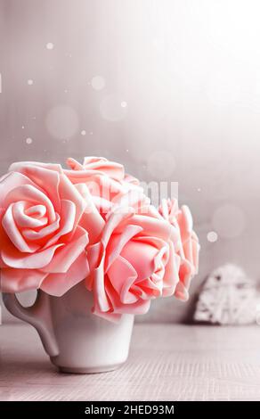 Rosen, Tasse und Herz auf grauem Hintergrund. Urlaubskonzept. Valentinstag. Stockfoto