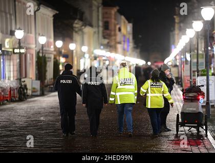 Potsdam, Deutschland. 10th Januar 2022. Am frühen Abend laufen Polizisten entlang der Brandenburger Straße durch die Potsdamer Innenstadt. Für den Abend am Brandenburger Tor wurden eine Demonstration gegen die Corona-Regeln und eine Gegendemonstration angekündigt. Quelle: Soeren Stache/dpa-Zentralbild/dpa/Alamy Live News Stockfoto