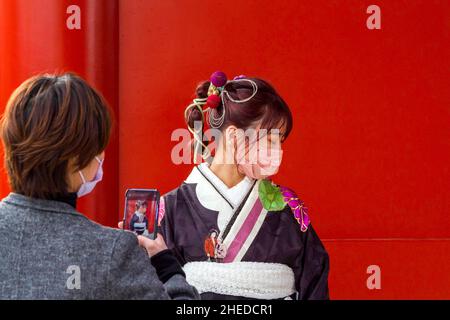 Tokio, Japan. 10th Januar 2022. Eine Mutter fotografiert ihre Tochter im traditionellen Kimono, während sie den Senso-ji-Tempel besucht, um Seijin no Hi (Coming of Age Day) zu feiern. Japanische Menschen, die in diesem Jahr ihren 20th. Geburtstag haben, feiern das Erreichen des Erwachsenenalters, indem sie sich in formelle Kleidung und schönen Kimono kleiden und Schreine und Tempel besuchen. (Foto von Damon Coulter/SOPA Images/Sipa USA) Quelle: SIPA USA/Alamy Live News Stockfoto