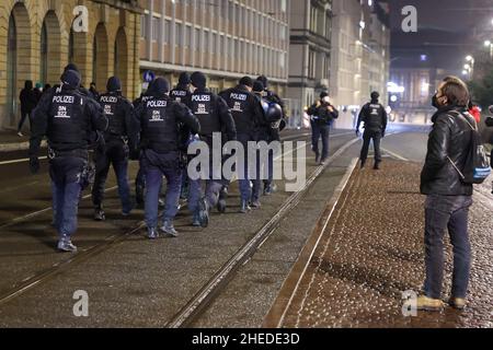 Leipzig, Deutschland. 10th Januar 2022. Die Polizei geht am Augustusplatz über eine Straße. Unter dem Motto "gemeinsam für Demokratie und Solidarität" finden in der Leipziger Innenstadt Demonstrationen von Linken, SPD, Grünen und dem Aktionsnetzwerk "Leipzig nimmt Platz" statt, als Protest gegen die Proteste gegen die Corona-Maßnahmen, an denen zahlreiche Rechtsextremisten teilnehmen und organisieren. In ganz Sachsen gibt es erneut mehrere Aufrufe an soziale Netzwerke zu Demonstrationen gegen Corona-Maßnahmen. Quelle: Jan Woitas/dpa/Alamy Live News Stockfoto