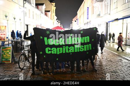 Potsdam, Deutschland. 10th Januar 2022. Auf der Brandenburger Straße halten Gegendemonstranten ein Transparent mit der Aufschrift „Kapitalismus sperren“. Für den Abend wurden eine Demonstration gegen die Corona-Regeln und eine Gegendemonstration am Brandenburger Tor angekündigt. Quelle: Soeren Stache/dpa-Zentralbild/dpa/Alamy Live News Stockfoto