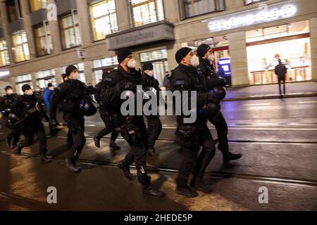 Leipzig, Deutschland. 10th Januar 2022. Am Augustusplatz laufen Polizeikräfte eine Straße entlang. Unter dem Motto "gemeinsam für Demokratie und Solidarität" finden in der Leipziger Innenstadt Demonstrationen von Linken, SPD, Grünen und dem Aktionsnetzwerk "Leipzig nimmt Platz" statt, als Protest gegen die Proteste gegen die Corona-Maßnahmen, an denen zahlreiche Rechtsextremisten teilnehmen und organisieren. In ganz Sachsen gibt es erneut mehrere Aufrufe an soziale Netzwerke zu Demonstrationen gegen Corona-Maßnahmen. Quelle: Jan Woitas/dpa/Alamy Live News Stockfoto