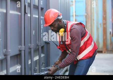 Vorarbeiter kontrollieren die Verladecontainer von Cargo Frachtschiff für den Import Export. Frachtcontainer im Seehafen. Stockfoto