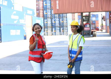 Vorarbeiter kontrollieren die Verladecontainer von Cargo Frachtschiff für den Import Export. Frachtcontainer im Seehafen. Stockfoto