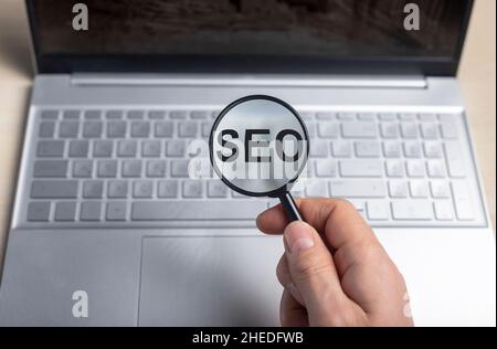 SEO, Suchmaschinenoptimierung Konzept. Wort durch Vergrößerungsglas. Stockfoto