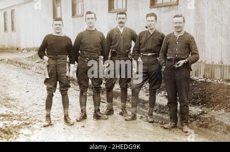 Eine Gruppe britischer Soldaten in informeller Uniform aus der Zeit des ersten Weltkrieges im Lager, außerhalb von Barackenhütten. Stockfoto