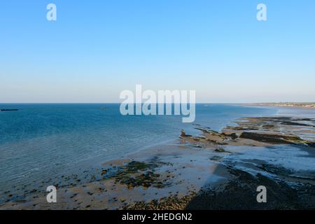 Dieses Landschaftsfoto wurde im Sommer in Europa, Frankreich und der Normandie aufgenommen. Wir können den Strand von Arromanches bei Ebbe und unter der Sonne sehen Stockfoto