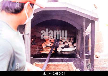 Tägliche Herstellung von Brot mit Holzofen nach traditioneller Methode gebacken Stockfoto