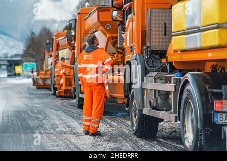 Liptovsky Hradok, Slowakei - 12. Februar 2020: Gruppe von hellorangen Straßenmeisterwagen mit Eisensalz, die sich im Winter vorbereiten, Schneekoje Stockfoto