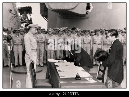 VJ Tag Zweiten Weltkrieg Sieg über Japan Japanische Kapitulation. Der japanische Außenminister Mamoru Shigemitsu unterzeichnet das Instrument der bedingungslosen Kapitulation im Namen der japanischen Regierung an Bord der USS Missouri, 2. September 1945. Lieutentant General Richard K. Sutherland, U.S. Army, beobachtet von der gegenüberliegenden Seite des Tisches. Der Vertreter des Außenministeriums, Toshikazu Kase, unterstützt Herrn Shigemitsu. Stockfoto