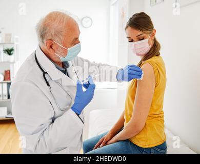 Impfung Medizin Spritze Impfstoff Arzt Injektion medizinische Gesundheit Virus Krankenhaus Pflege Patient Grippe Maske Coronavirus Corona Senior Stockfoto