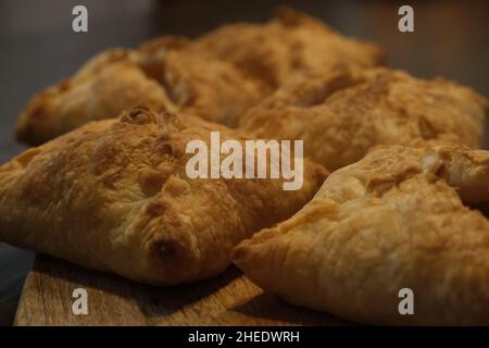 Frische, hausgemachte Apfeltaschen mit Golden Crust auf einem hölzernen Servierbrett Stockfoto