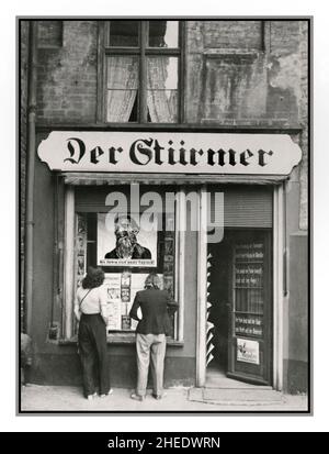 DER STURMER NSDAP Nazi Anti-jüdische Rassismus Propaganda Zeitungsausgangsbüros DER NS-Zeitung DER STURMER Danzig in Polen, 1930er Jahre Auf einem antisemitischen Poster im Fenster steht: „Die Juden sind unser Ungluck!“ Der Stürmer Boulevardzeitung Wochenzeitung von Julius Streicher, dem Gauleiter von Franken, von 1923 bis zum Ende des Zweiten Weltkriegs Nürnberg Nazi-Deutschland im Zweiten Weltkrieg genehmigte Streicher regelmäßig Artikel, die die Vernichtung und Vernichtung der jüdischen Rasse forderten. Der Stürmer war vor allem für seine antisemitischen Karikaturen bekannt. Stockfoto
