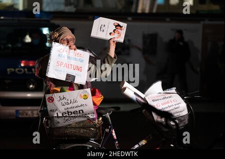 Köln, Deutschland. 10th Januar 2022. Ein Demonstrator hält Protestplakate gegen die Corona-Maßnahmen. In Köln gingen am Montagabend mehr als 1000 Menschen gegen die Corona-Maßnahmen auf die Straße. Quelle: Federico Gambarini/dpa/Alamy Live News Stockfoto