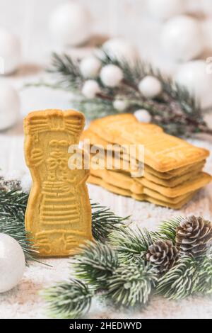 SPECULOOS Kekse auf weißem Hintergrund mit weihnachtlicher Dekoration. Europäische Spezialität zu Weihnachten. Vertikal. Stockfoto