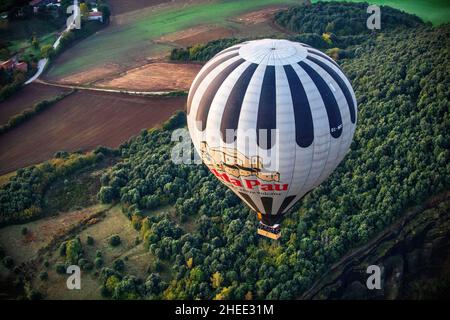 Heißluftballon mit offenem Vulkan und Bergen im Hintergrund in der Provinz Garrotxa Olot Girona Katalonien, Spanien Stockfoto