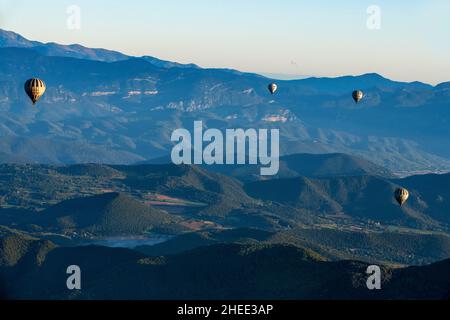 Heißluftballon, der La Fageda d' en Jordà und das vulkanische Gebiet von Olot, den Naturpark der vulkanischen Zone von La Garrotxa und die Berge auf dem fliegt Stockfoto