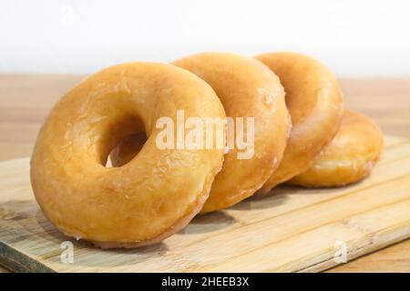 Hausgemachte klassische Donuts auf einem Holzständer. Frühstückskonzept. Stockfoto