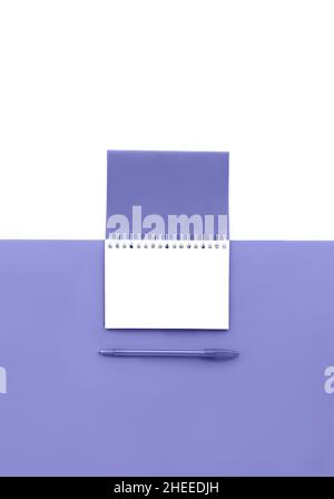 Draufsicht auf geöffneten Spiralnotepad mit Stift getönt in Trendfarbe des Jahres 2022 mit isolierter weißer Seite. Modell für Ihr Design. Speicherplatz kopieren. Stockfoto